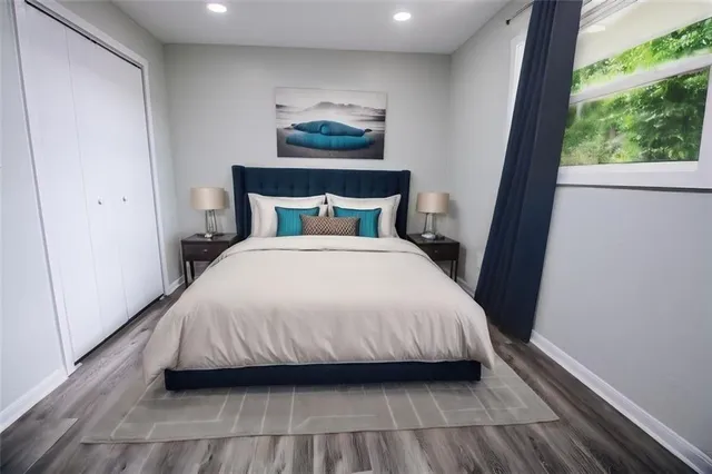 a bedroom with a bed and a painting on the wall