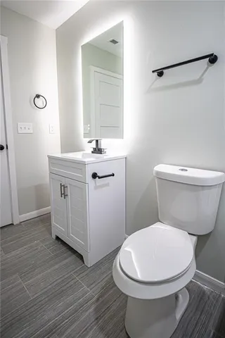 a bathroom with a toilet a sink and a mirror