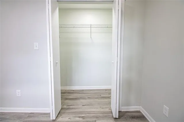 a view of an empty walk in closet with wooden floor