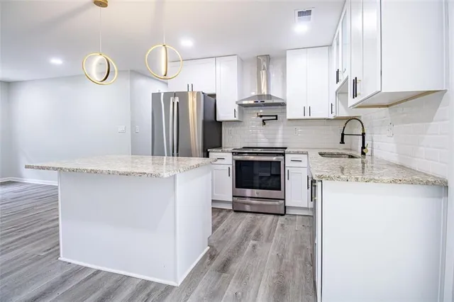 a kitchen with stainless steel appliances granite countertop a sink stove and refrigerator