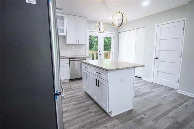 a kitchen with white cabinets and window