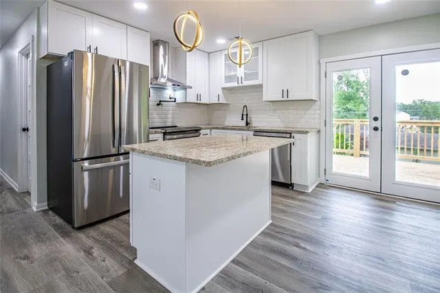 a kitchen with a refrigerator sink and cabinets