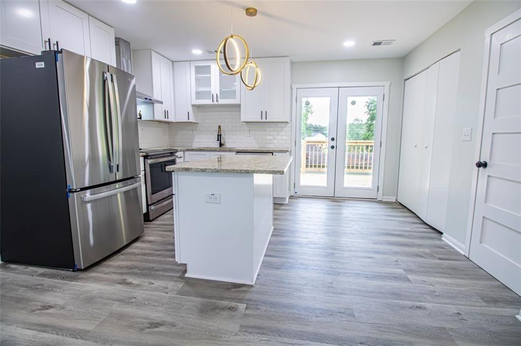 3699 Larkspur Terrace Decatur, GA 30032 - Photo 9 of 29 a kitchen with stainless steel appliances granite countertop a refrigerator a sink dishwasher a stove and a wooden floor