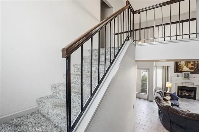 a view of staircase with wooden floor and a fireplace
