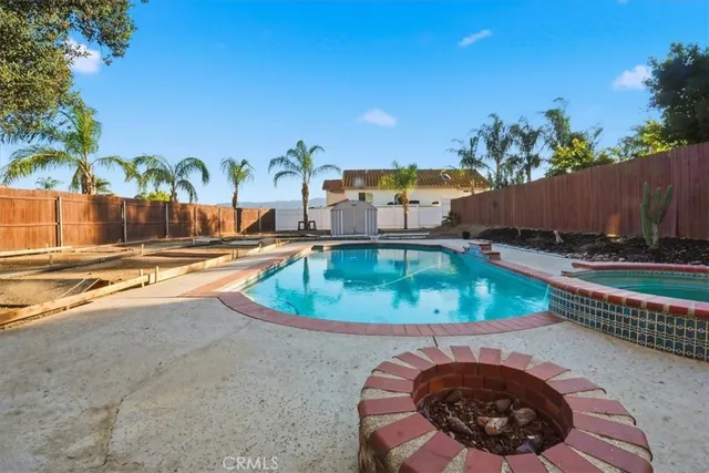 swimming pool view with a seating space and a garden