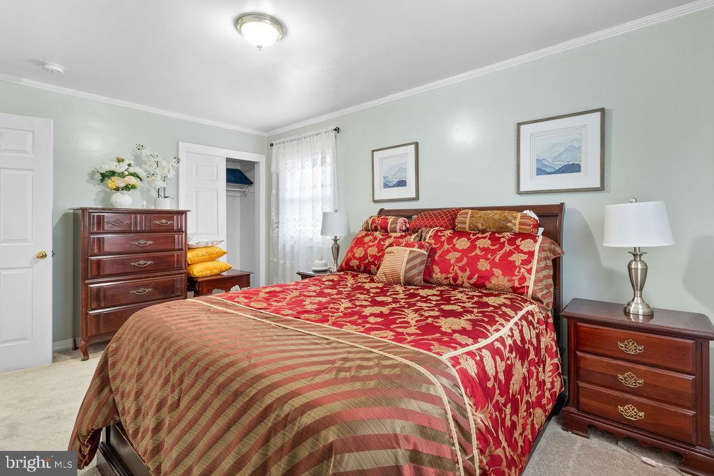 607 Valley Brook Drive Silver Spring, MD 20904 - Photo 19 of 67 a bedroom with a bed and a lamp on dresser