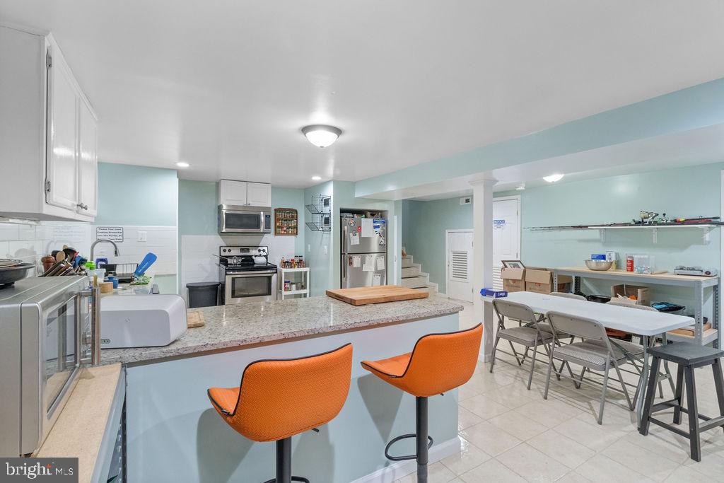 607 Valley Brook Drive Silver Spring, MD 20904 - Photo 48 of 67 a kitchen with stainless steel appliances kitchen island granite countertop a table and chairs in it