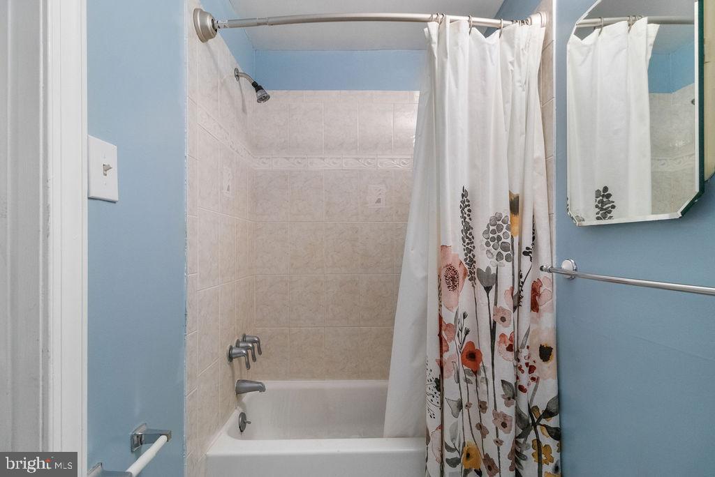 607 Valley Brook Drive Silver Spring, MD 20904 - Photo 55 of 67 a bathroom with a shower curtain and a bathtub