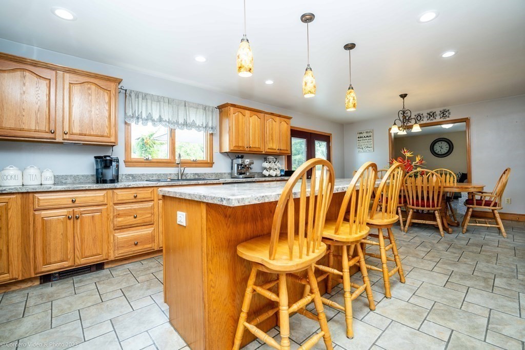 27 Peach Blossom Road Acushnet, MA 02743 - Photo 4 of 42 a kitchen with stainless steel appliances granite countertop wooden cabinets a dining table and chairs
