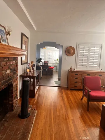 a living room with furniture a fireplace and wooden floor