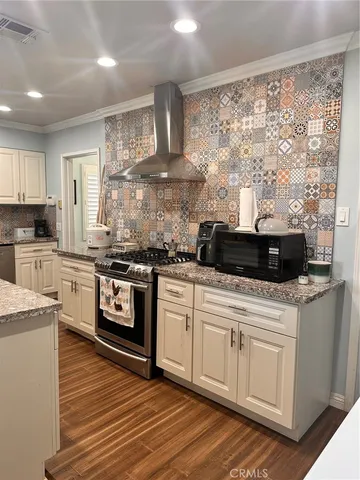 a kitchen with stainless steel appliances granite countertop a refrigerator a stove top oven a sink and a refrigerator