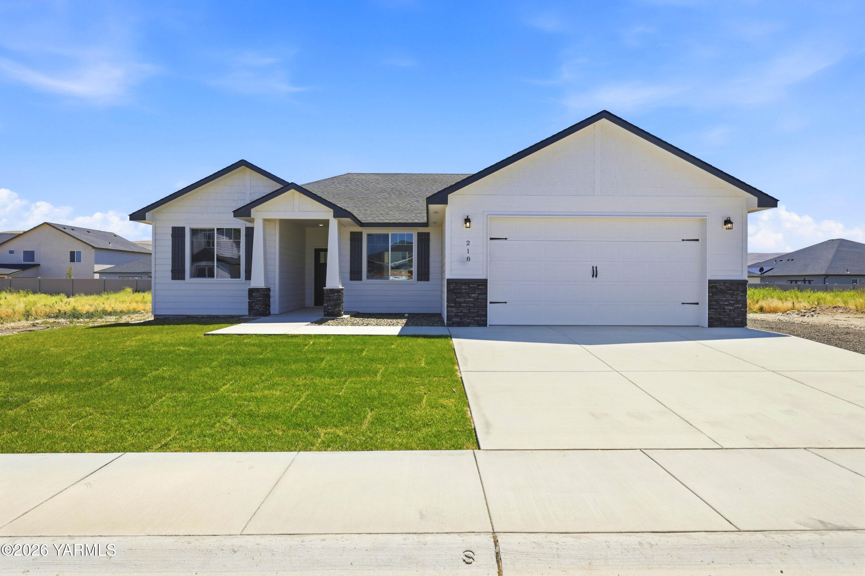 218 Packer Street Prosser, WA 99350 - Photo 1 of 36 a front view of a house with a yard and garage
