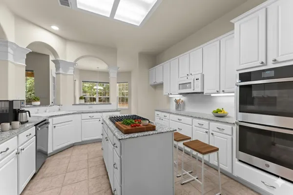 a kitchen with granite countertop a sink stove and cabinets
