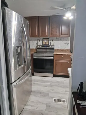 a kitchen with granite countertop a refrigerator and a stove