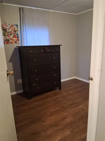a room with a dresser and wooden floor