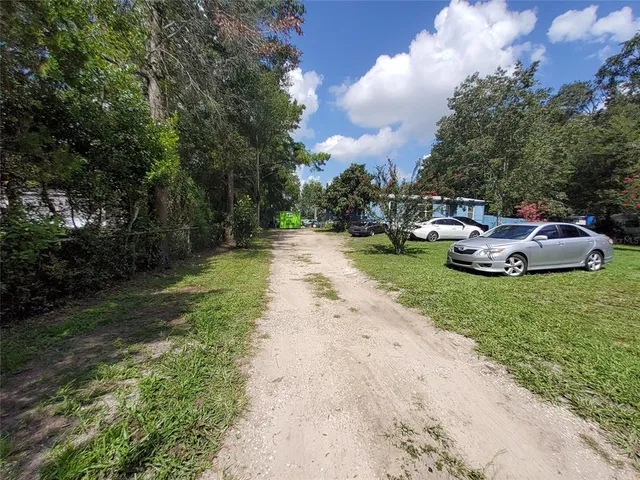 a front view of a house with garden and trees