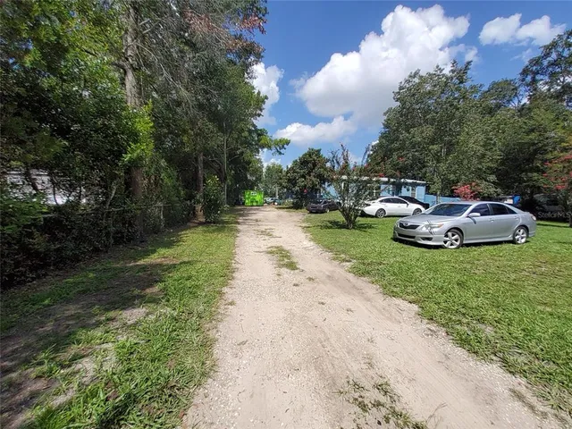 a front view of a house with a garden and trees