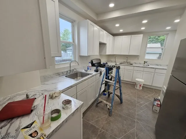 a kitchen with a sink a stove a refrigerator and cabinets