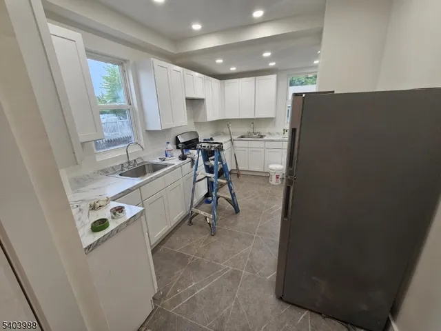 a kitchen with a sink a refrigerator and a window