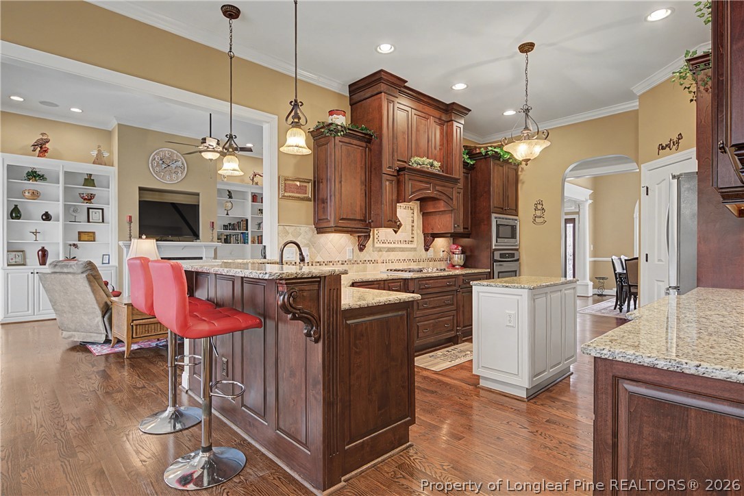 115 Micahs Way North Spring Lake, NC 28390 - Photo 18 of 39 a kitchen with stainless steel appliances kitchen island granite countertop a table chairs and a sink