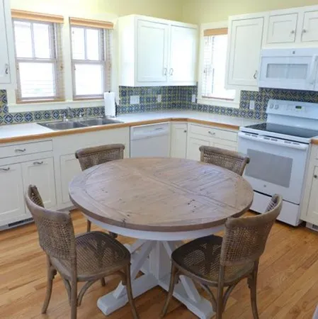 a kitchen with a table chairs sink and cabinets