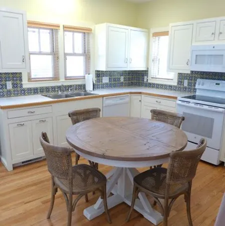 a kitchen with a table chairs sink and cabinets