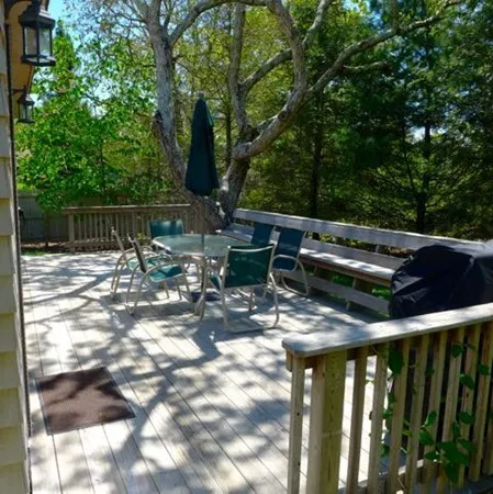 a view of deck with furniture and trees