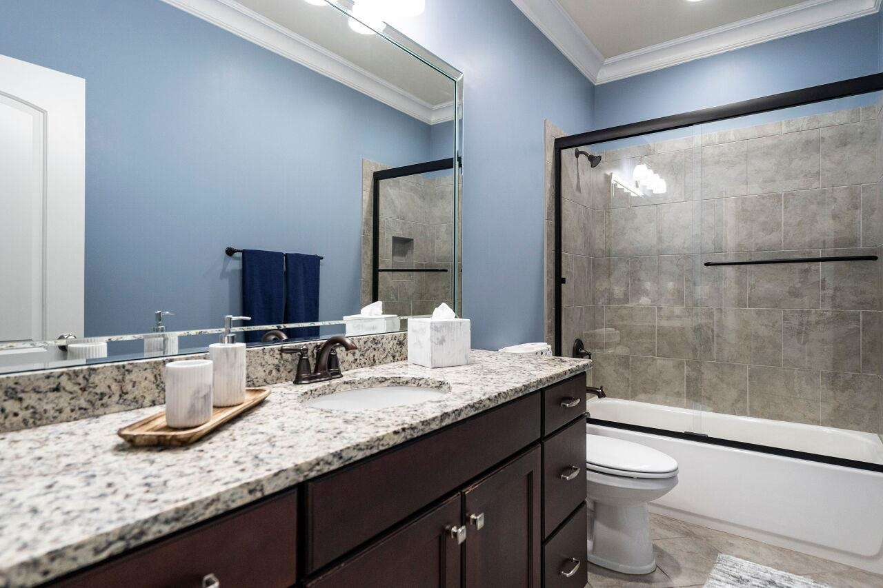 8401 Bournemouth Drive Raleigh, NC 27615 - Photo 28 of 41 Bathroom with raised stain cabinet vanity, granite tops, tub/shower with glass door and tile floors. Bathroom 3