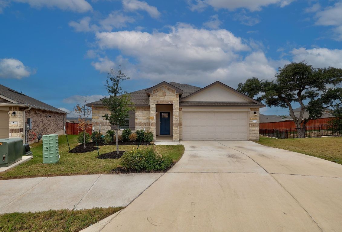 Ranch-style house featuring stone siding, concrete driveway, and an attached garage