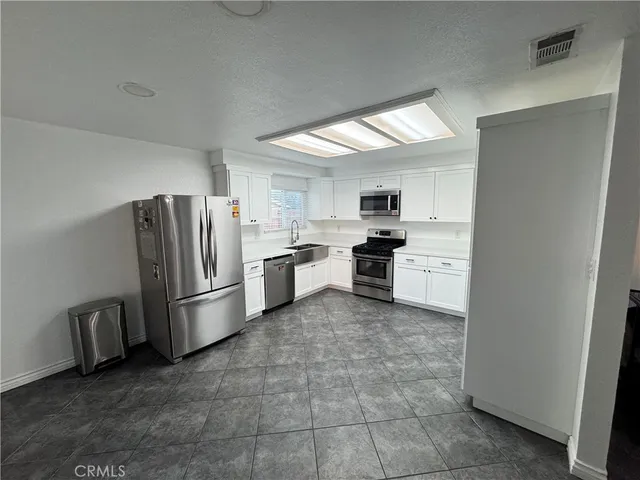 a kitchen with cabinets stainless steel appliances and a counter space