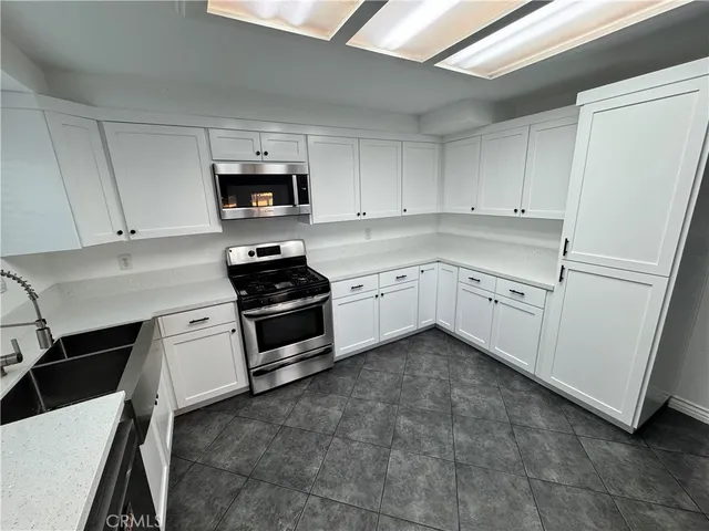 a kitchen with stainless steel appliances a refrigerator sink and microwave