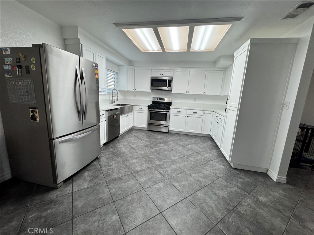 40471 Rome Beauty Way Cherry Valley, CA 92223 - Photo 9 of 32 a kitchen with stainless steel appliances a refrigerator sink and microwave