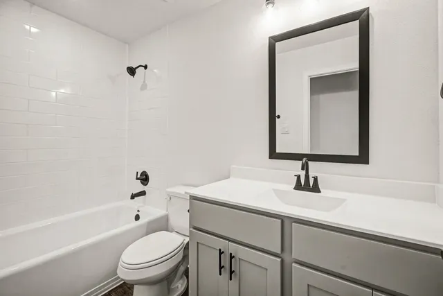 a bathroom with a sink toilet vanity and tub