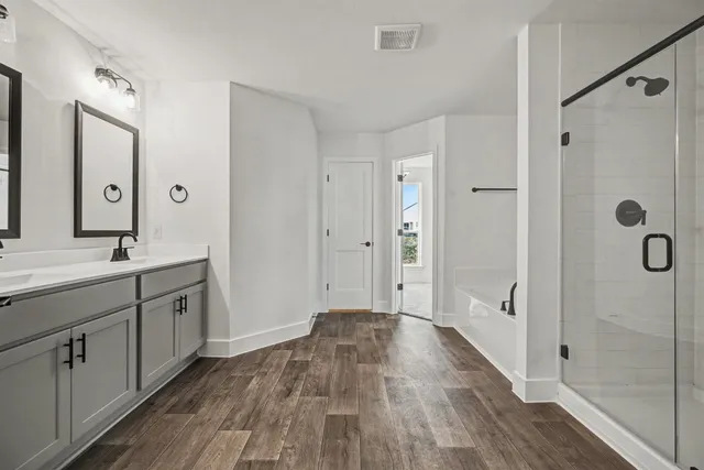 a spacious bathroom with a double vanity sink a mirror and shower
