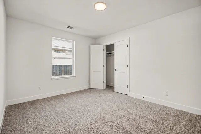 an empty room with windows and closet