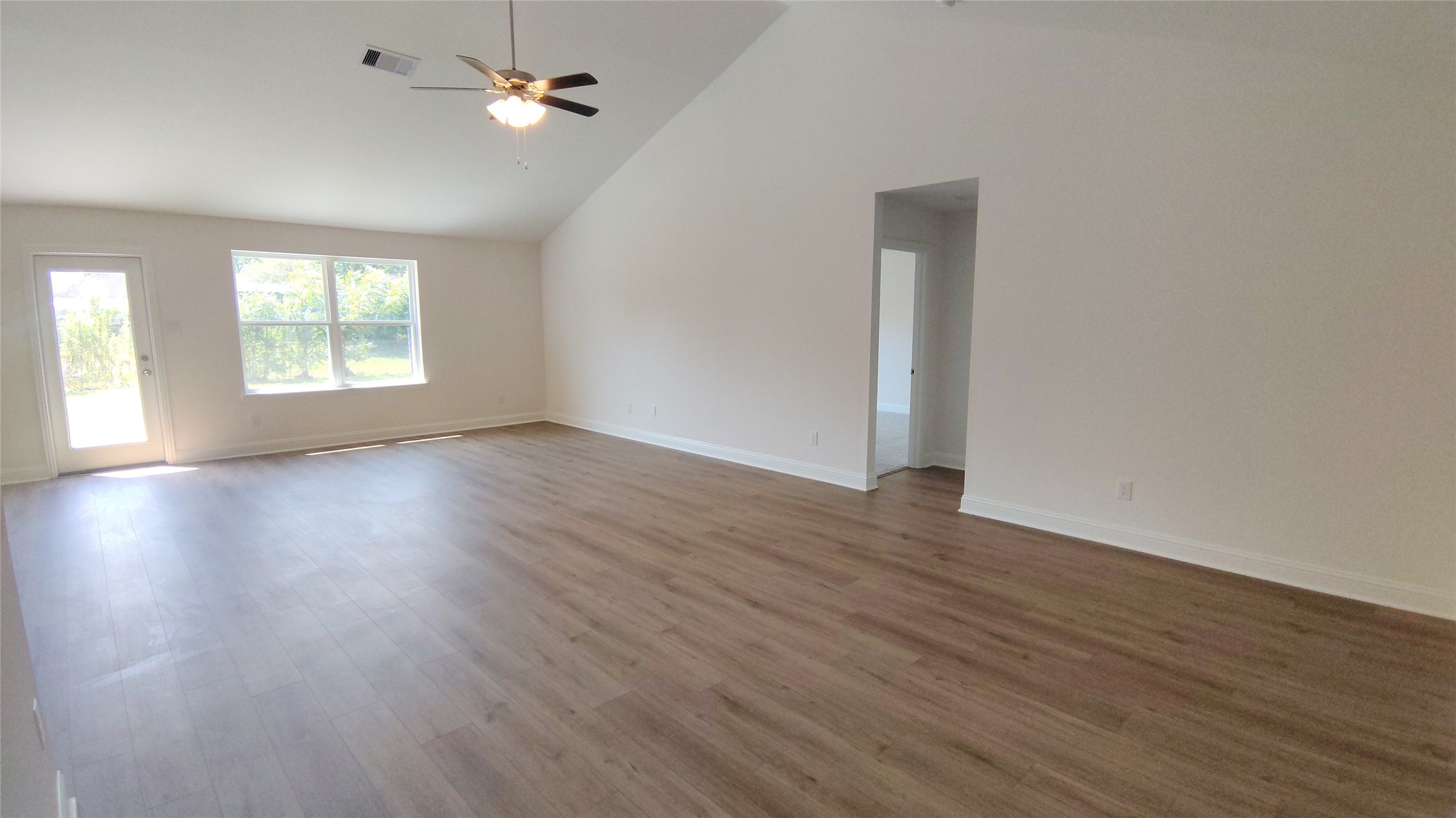 644 Greystone Lane Angleton, TX 77515 - Photo 6 of 21 an empty room with wooden floor chandelier fan and windows