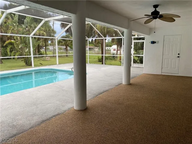 a view of an empty room with a window and a ceiling fan