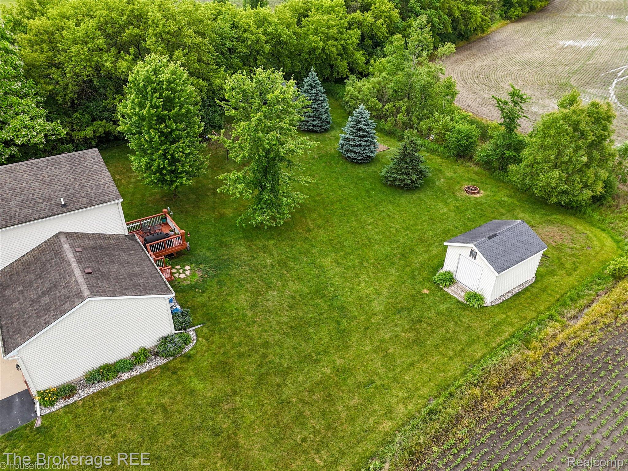 4432 North Belsay Road Flint, MI 48506 - Photo 24 of 79 Expansive green yard featuring mature trees, a multi-level wood deck, and a white storage shed with dark shingles