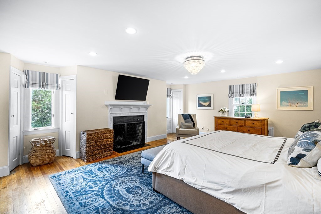 642 Centre Street Newton, MA 02458 - Photo 15 of 26 a spacious bedroom with a bed and a fireplace