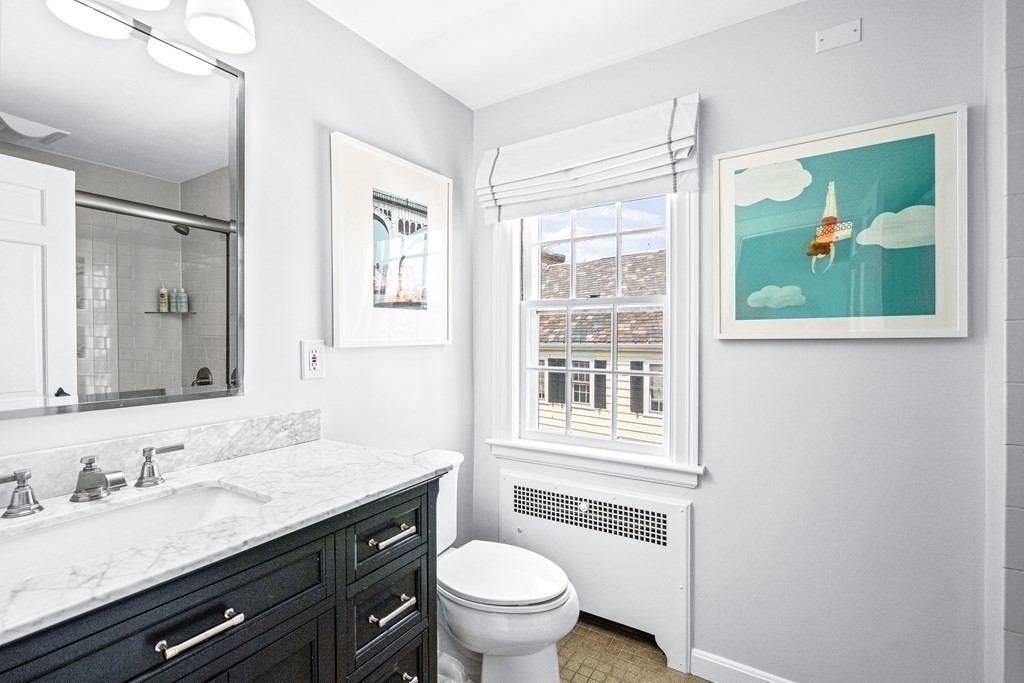 642 Centre Street Newton, MA 02458 - Photo 17 of 26 a bathroom with a granite countertop toilet sink and mirror