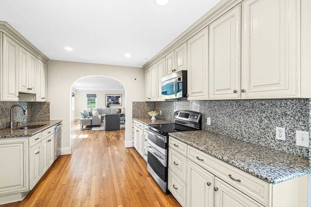 642 Centre Street Newton, MA 02458 - Photo 10 of 26 a kitchen with granite countertop a sink a counter space cabinets and stainless steel appliances