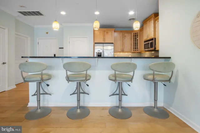 a kitchen with stainless steel appliances kitchen island a table and chairs in it