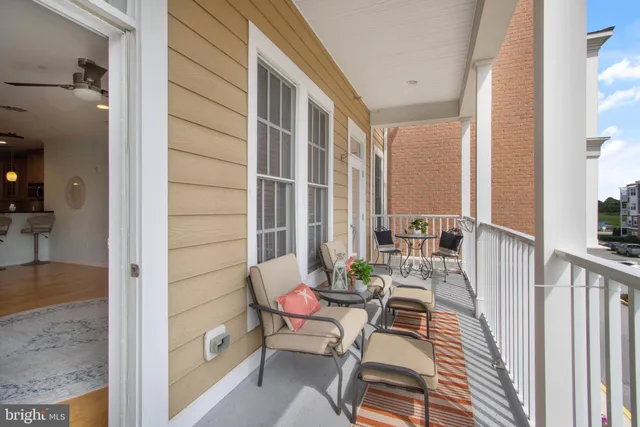 a balcony with chairs and with potted plants