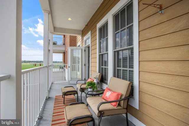 a balcony with couple of chairs and wooden floor