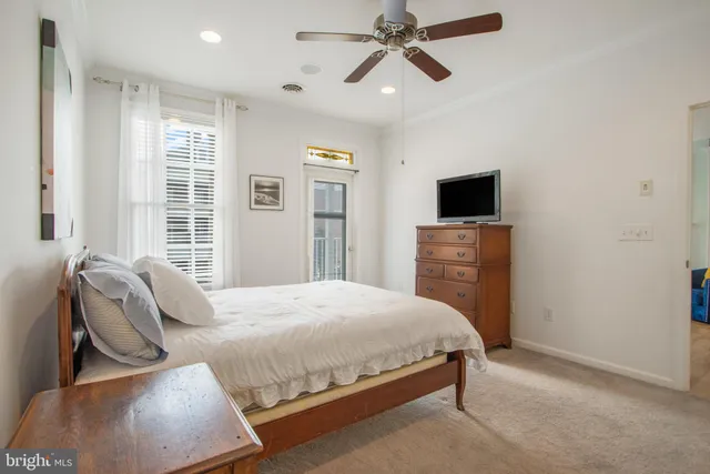 a bedroom with a bed a window and a flat screen tv