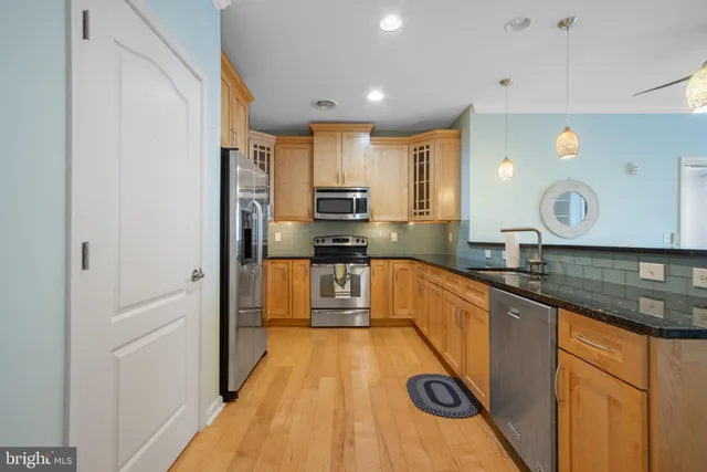 a large kitchen with stainless steel appliances granite countertop a sink and cabinets