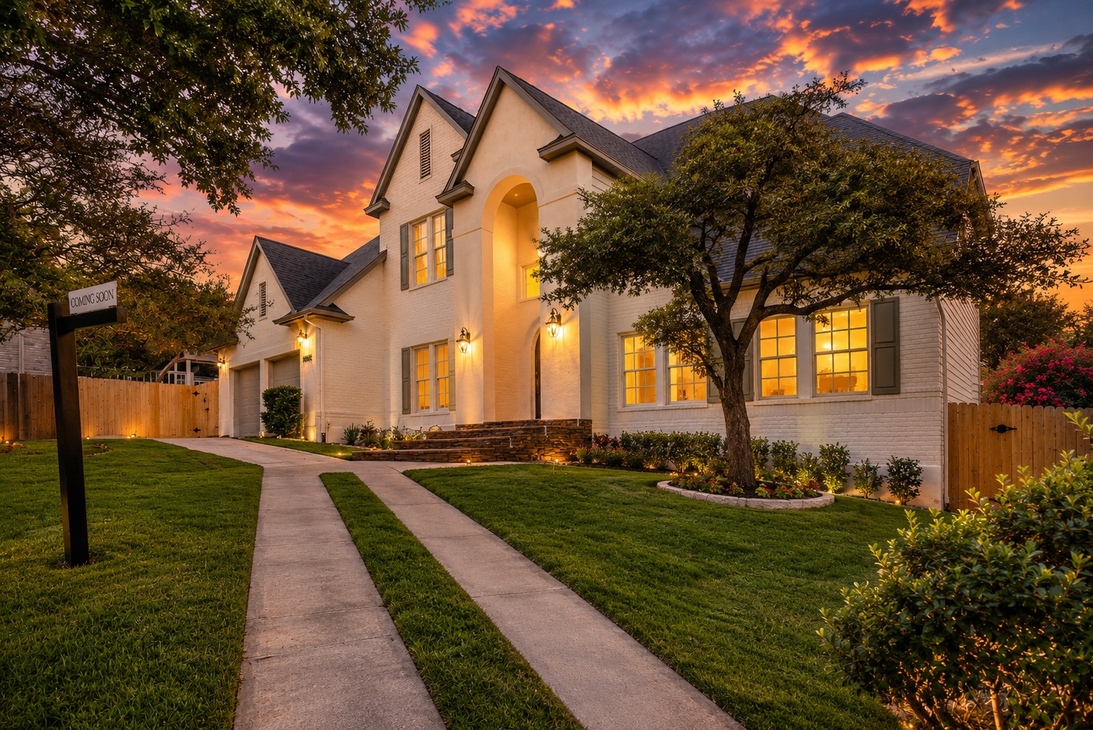 Illuminated by a vibrant sunset, this elegant home showcases a well-manicured lawn and inviting entryway.