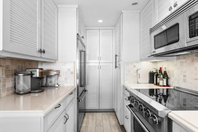 a kitchen with stainless steel appliances a sink a stove and cabinets