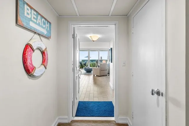 a view of a hallway with wooden floor and a dining room