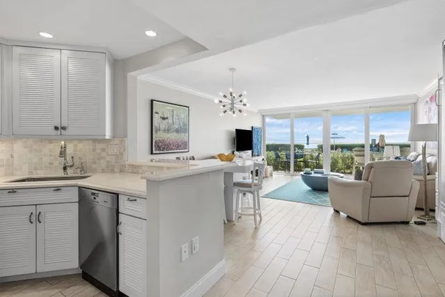 a living room with furniture a flat screen tv and kitchen view